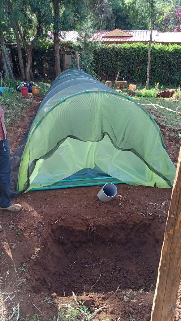 A biodigester installed alongside its excavated inlet pit